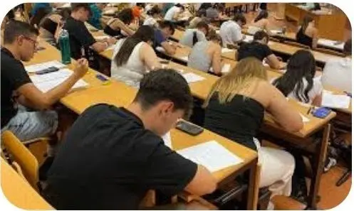 Aspirantes realizan una prueba escrita de oposiciones en un aula
